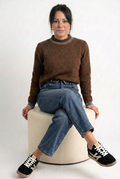 Jeans indossato con maglione marrone e sneakers