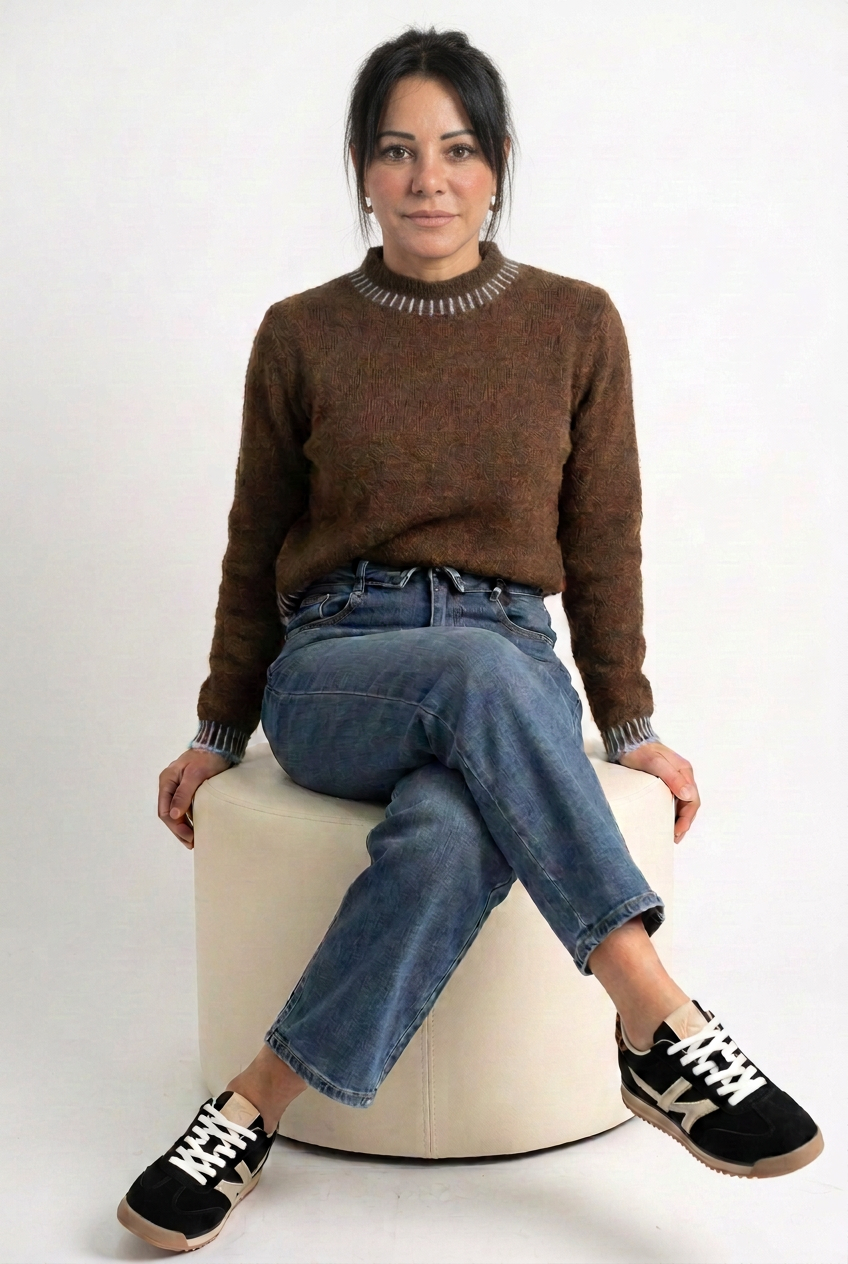 Jeans indossato con maglione marrone e sneakers