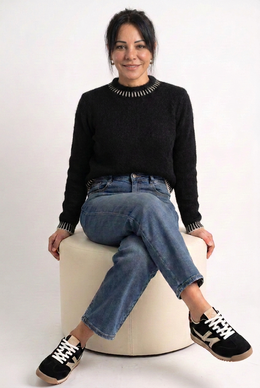 Jeans indossato con maglione nero e sneakers