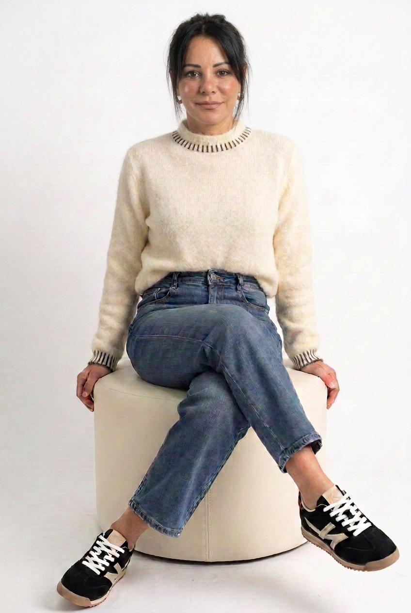 Jeans indossato con maglione panna e sneakers